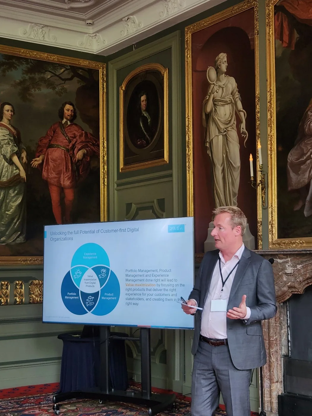 Rik discussing customer-first digital organizations beside a DASA presentation.